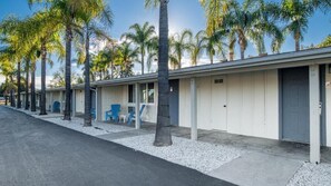 A row of single-story motel buildings with individual driveways and palm trees. - Fallbrook Country Inn (Fallbrook)