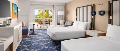 A hotel room with two beds, a desk, a chair, a balcony with a view, and a ceiling fan.
