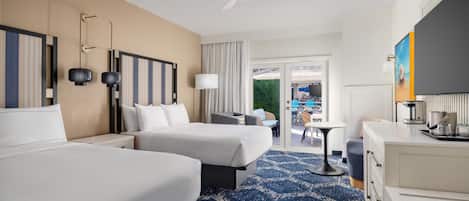 Habitación de hotel con dos camas, un escritorio, una silla, una cafetera y vistas al área exterior.