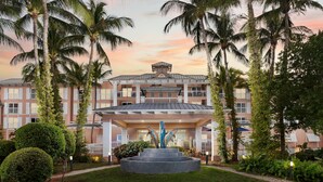 Un hôtel doté d’une cour intérieure, de palmiers et d’une fontaine.