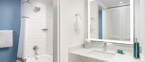 Un baño moderno con ducha, lavabo y espejo.