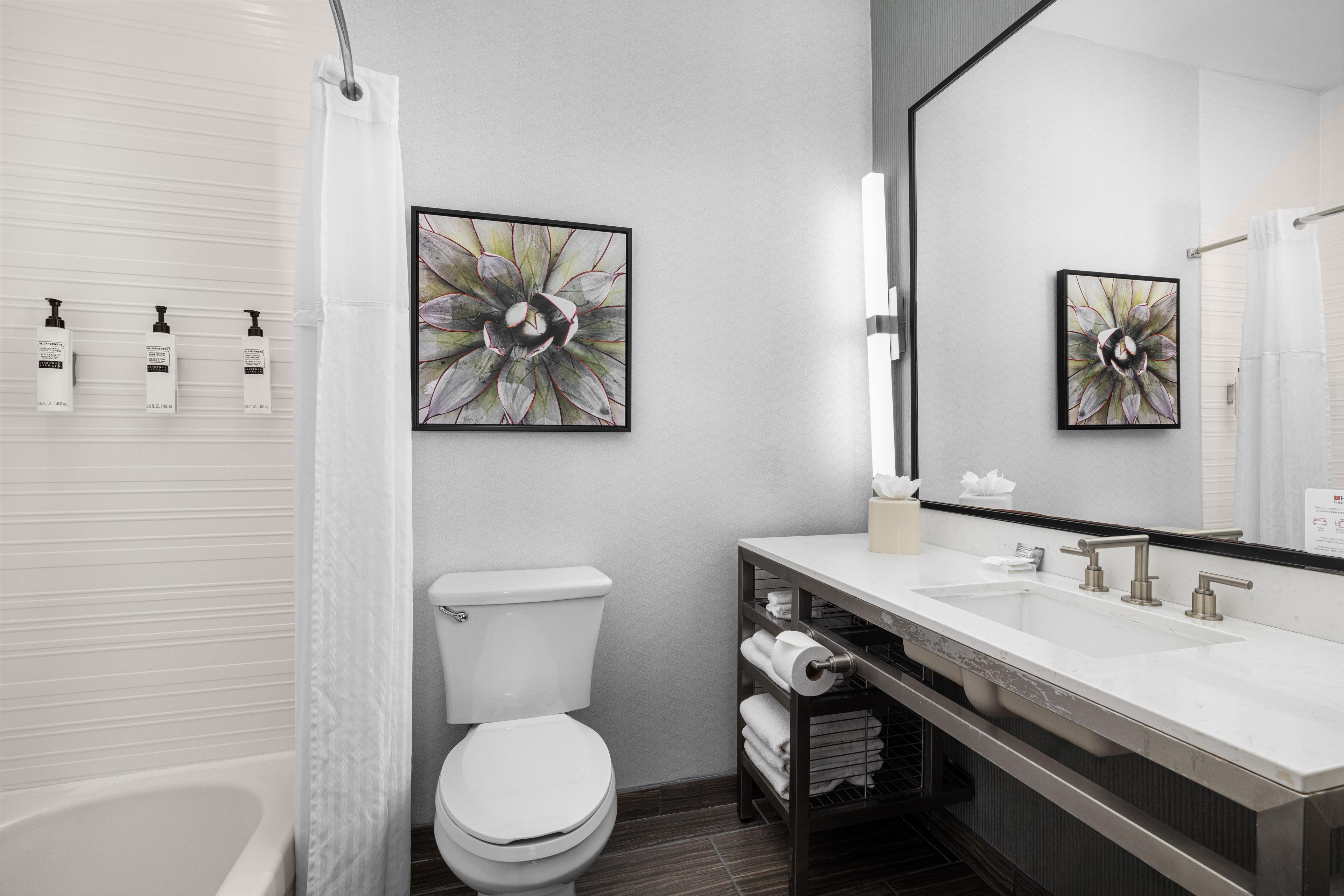 A modern bathroom with a toilet, sink, and shower.