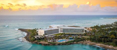 A resort with multiple buildings, a pool area, and a beach.