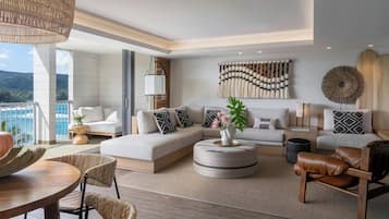 Ein modernes Wohnzimmer mit einer großen Eckcouch, einem runden Couchtisch und einem Essbereich mit Holztisch und Stühlen.