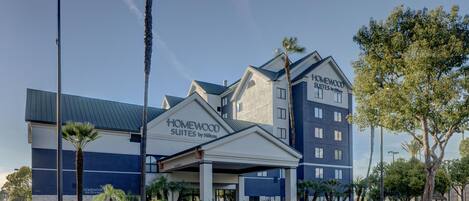 A hotel with a modern design, featuring a prominent entrance and a flagpole with the American flag.