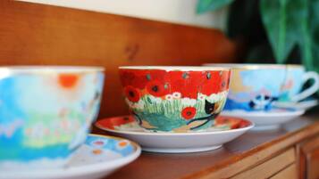 Un meuble en bois contenant trois tasses et soucoupes en céramique.