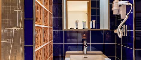 A bathroom with a shower, sink, and a mirror.
