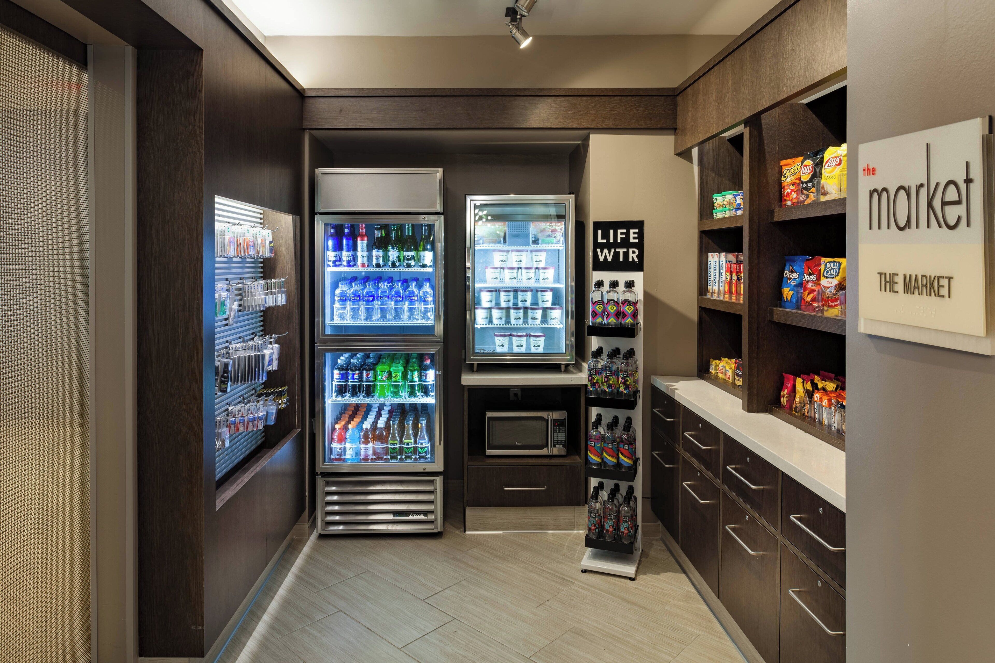 A kitchenette area with a refrigerator, microwave, and vending machines.