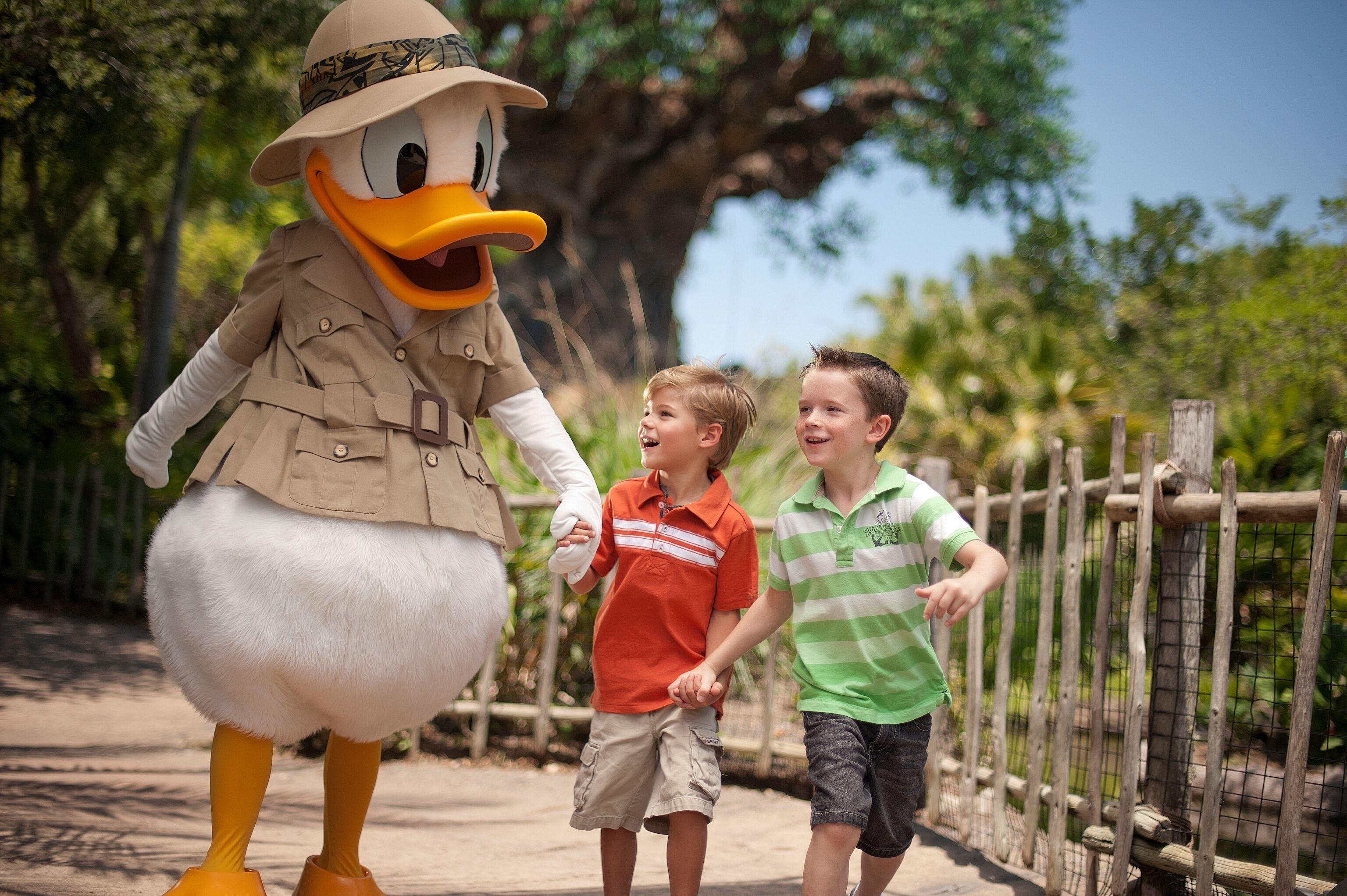A mascot in a safari outfit interacting with two children.