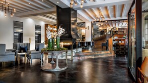 Un interior moderno con chimenea, zona de estar y escalera que sube a plantas superiores.