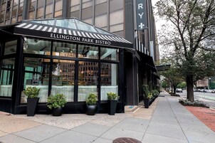 Exterior del Bistro Ellington Park con amplios ventanales y plantas en macetas al frente.