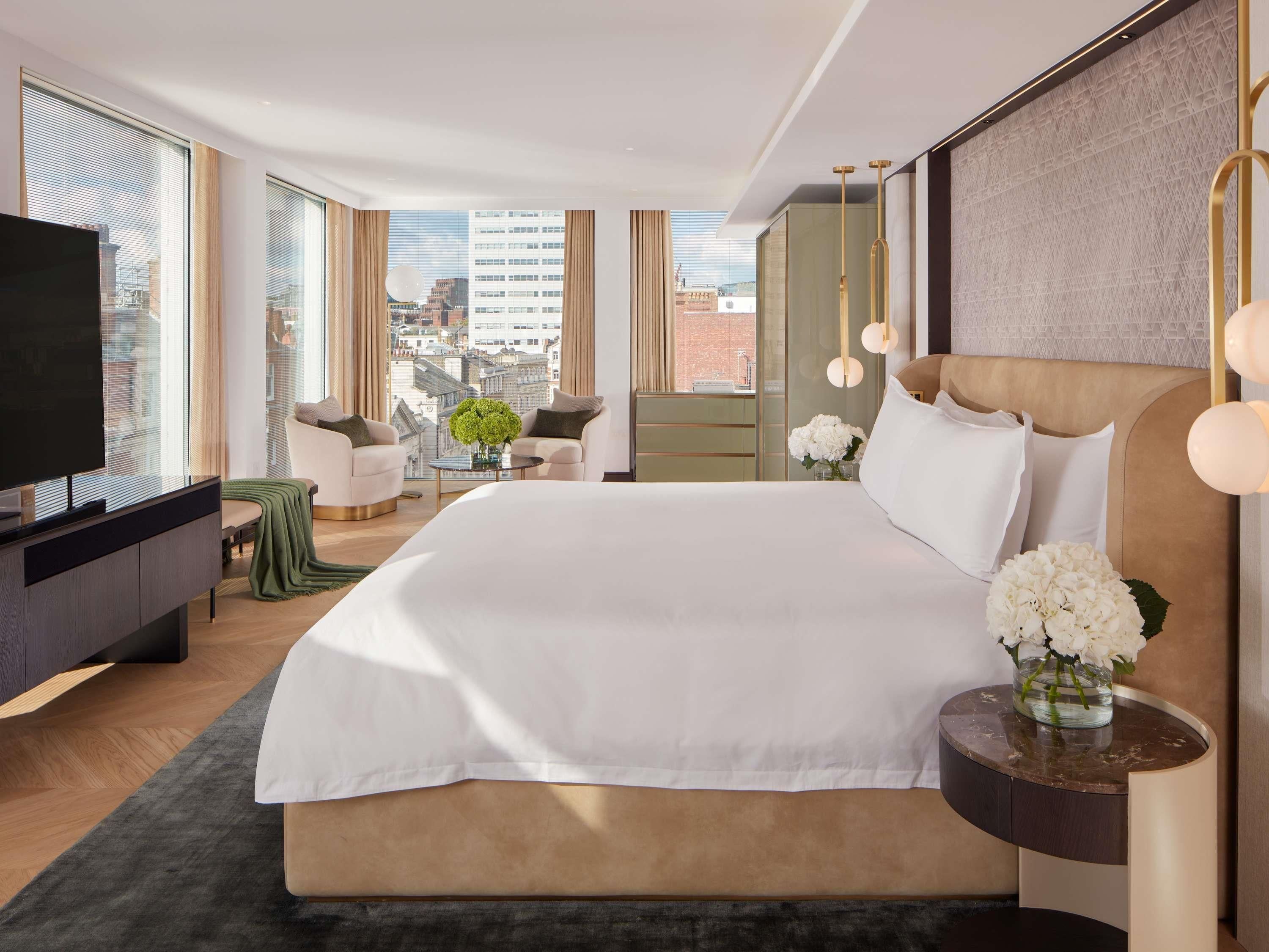 Une chambre d’hôtel moderne avec un grand lit, une télévision et une vue sur la ville.