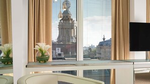 Una habitación de hotel moderna con un ventanal grande, un escritorio y una silla.