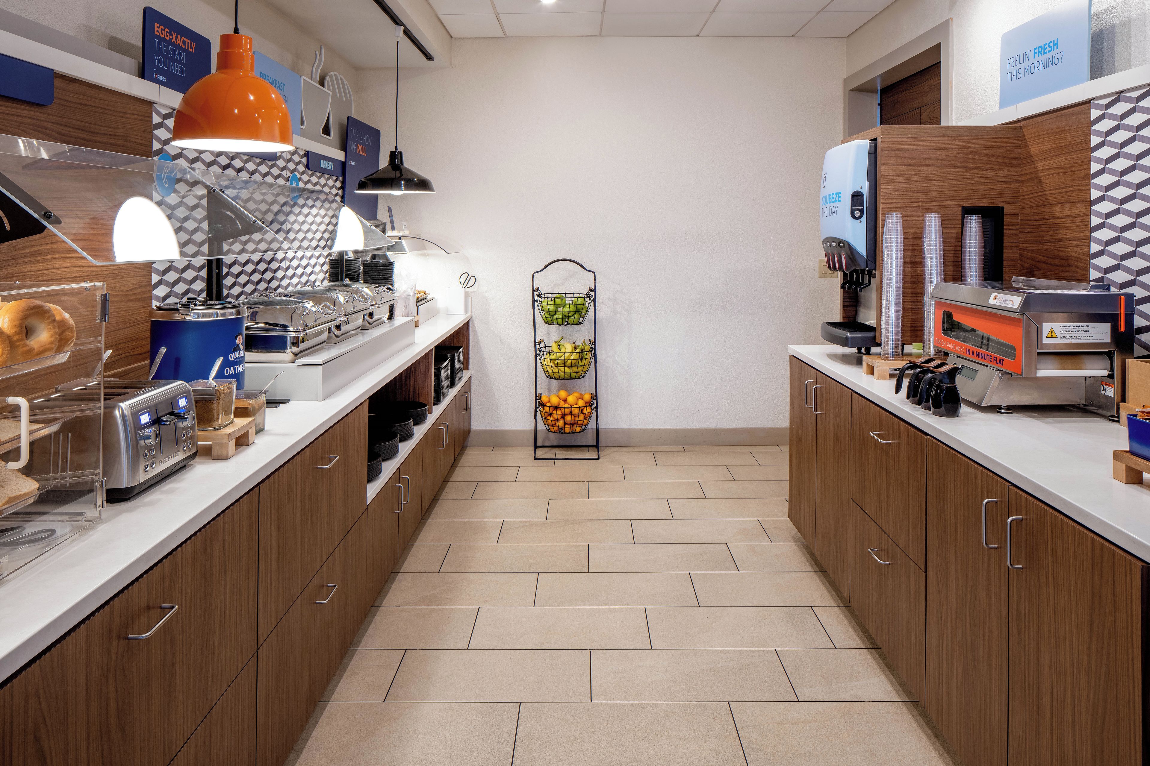 A modern kitchen with a central island, equipped with a coffee machine, toaster, and various food containers.