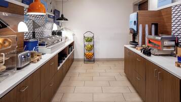 A modern kitchen with a central island, equipped with a coffee machine, toaster, and various food containers.