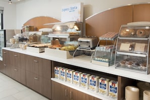 Un bufé de desayuno con diversas opciones de comida, una estación de café y un cartel que dice 'Express Start'.