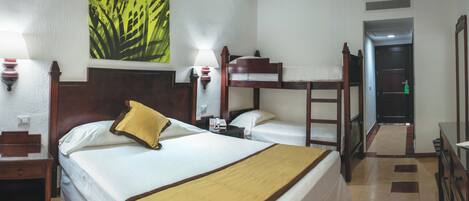 A hotel room with two beds, a bedside table with a lamp, a telephone, and a painting on the wall.
