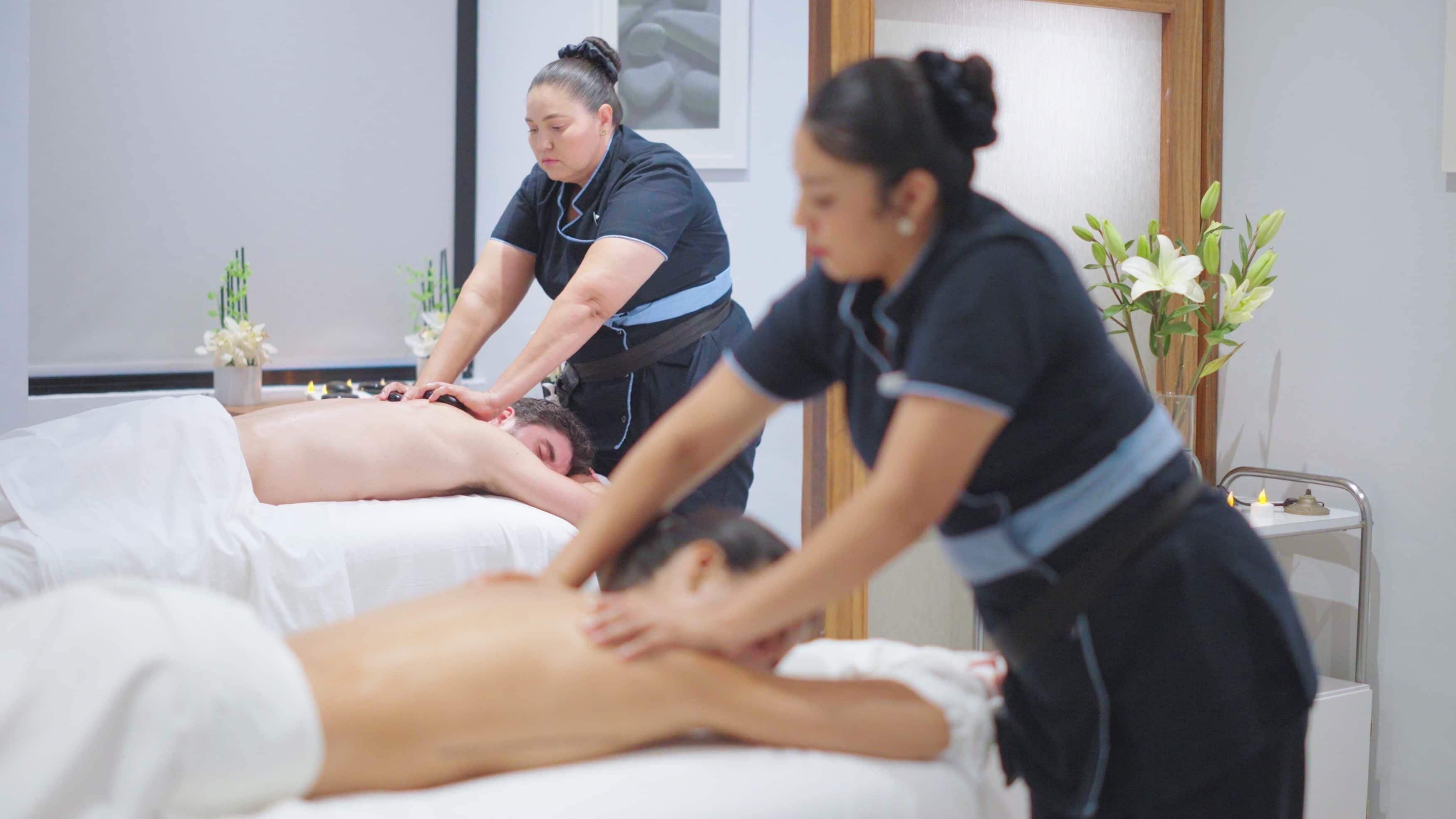 A massage therapy room with two clients receiving treatment.