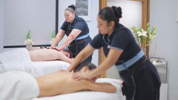 Une salle de massage où deux clients reçoivent des soins.