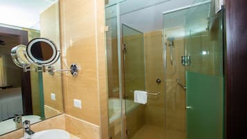 Ein modernes Badezimmer mit einer Duschkabine aus Glas, einem Waschbecken inklusive Spiegel und einem Handtuchhalter.