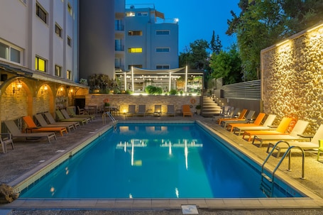 Una piscina al aire libre, sombrillas, sillones reclinables de piscina. Hotel Palmyra Beach