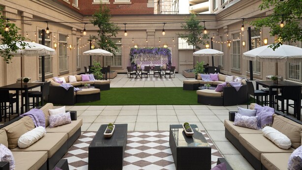 An outdoor patio with seating areas, tables, and string lights.