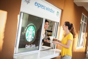 Een Starbucks Express raam met een persoon die bij de balie bestelt.