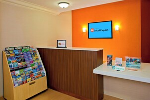 A reception desk with a sign reading "Local Expert" and a display of travel guides.