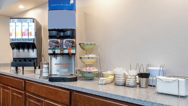 Een automaat voor zelfbediening met verschillende tappunten, waaronder een koffieapparaat en een waterkraan.