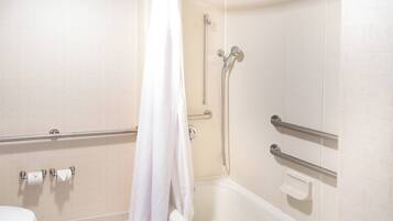 A bathroom with a bathtub, shower, and toilet.