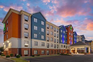 A multi-story hotel with a modern design, featuring a variety of room types and a covered entrance. - HOLIDAY INN EXPRESS & SUITES INDIANAPOLIS - EAST by IHG (Indianapolis)