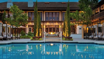 Una piscina al aire libre, camas de piscina con cargo, sombrillas