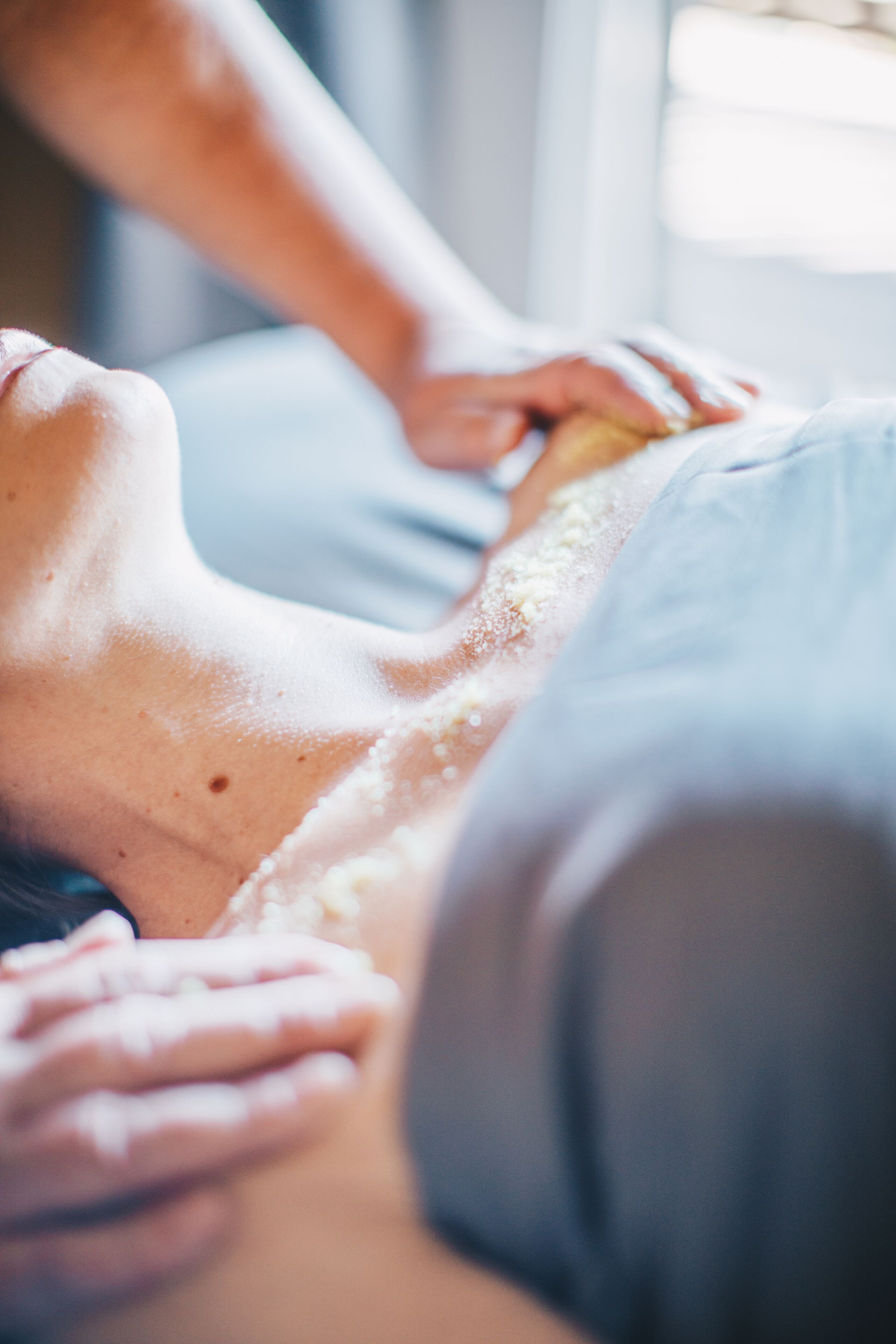 Gros plan sur une séance de massage, avec un accent particulier sur les mains et le haut du corps.