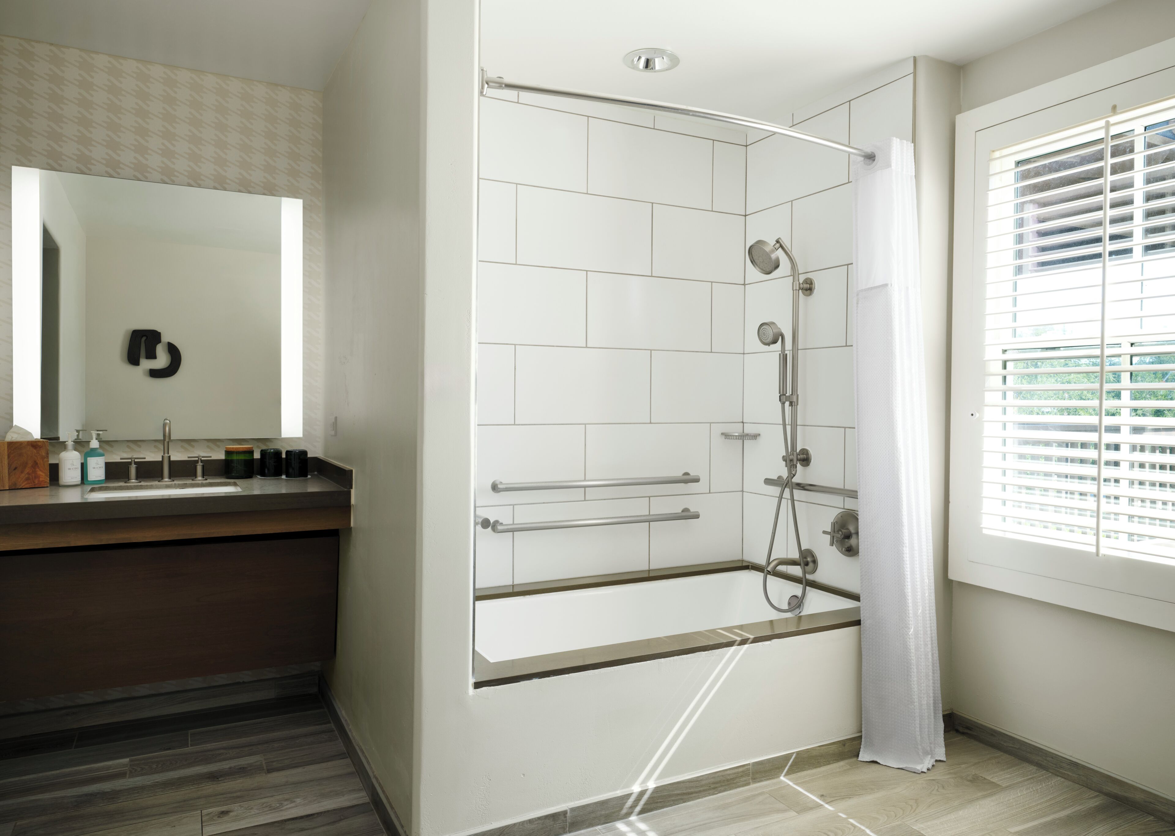 A modern bathroom with a shower, a vanity with a sink, and a large mirror.