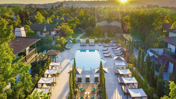 Un resort con piscina, sillones de sol y vistas del paisaje circundante.