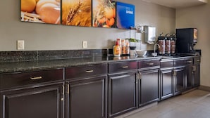 A kitchen with dark cabinets, a black countertop, and a coffee machine. - Comfort Inn & Suites Fruita - Grand Junction (Fruita)