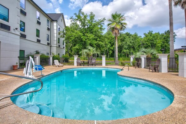 En säsongsöppen utomhuspool och solstolar