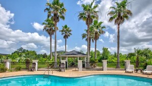A swimming pool with a gazebo and palm trees in the background. - Wingate by Wyndham Biloxi/Ocean Springs (Biloxi)
