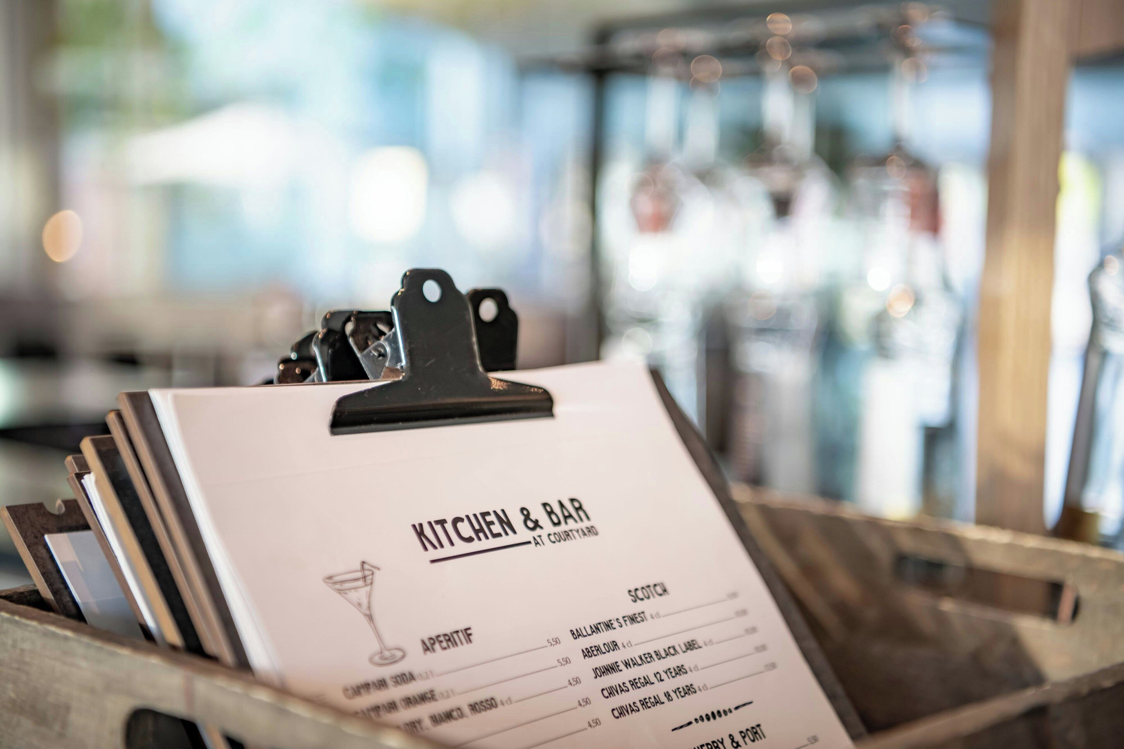 Un panneau affichant le menu, intitulé « CUISINE ET BAR », sur lequel figure une variété de boissons proposées.