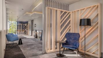 A modern office space with a grey carpet, wooden partitions, and blue chairs.