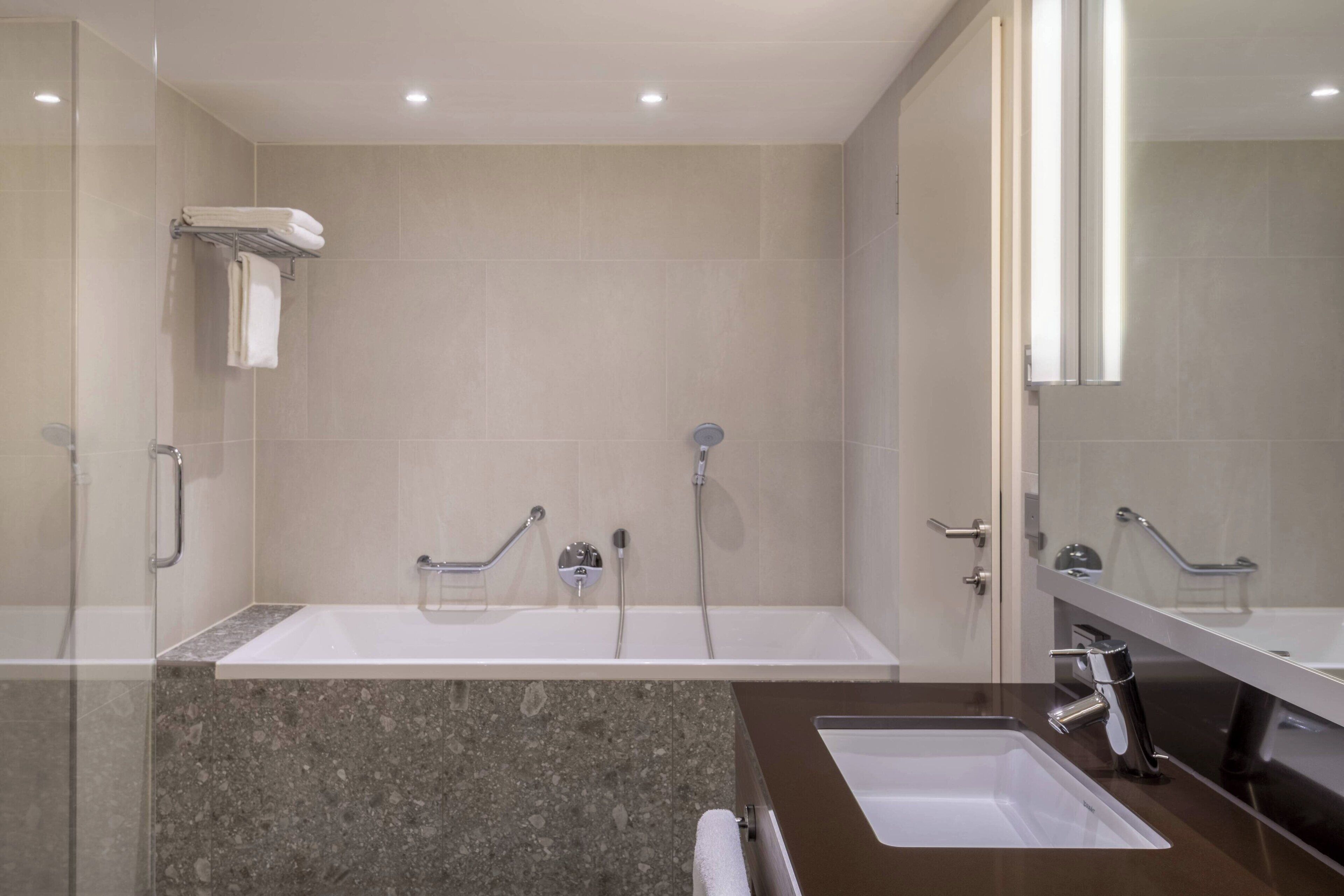 Ein modernes Badezimmer mit zwei Waschbecken, einer Dusche und einer Duschkabine.