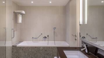 Un baño moderno con dos lavamanos, ducha y zona de ducha con mampara de vidrio.