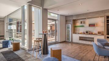 A modern kitchen with a large island, open-plan layout, and a dining area with stools.