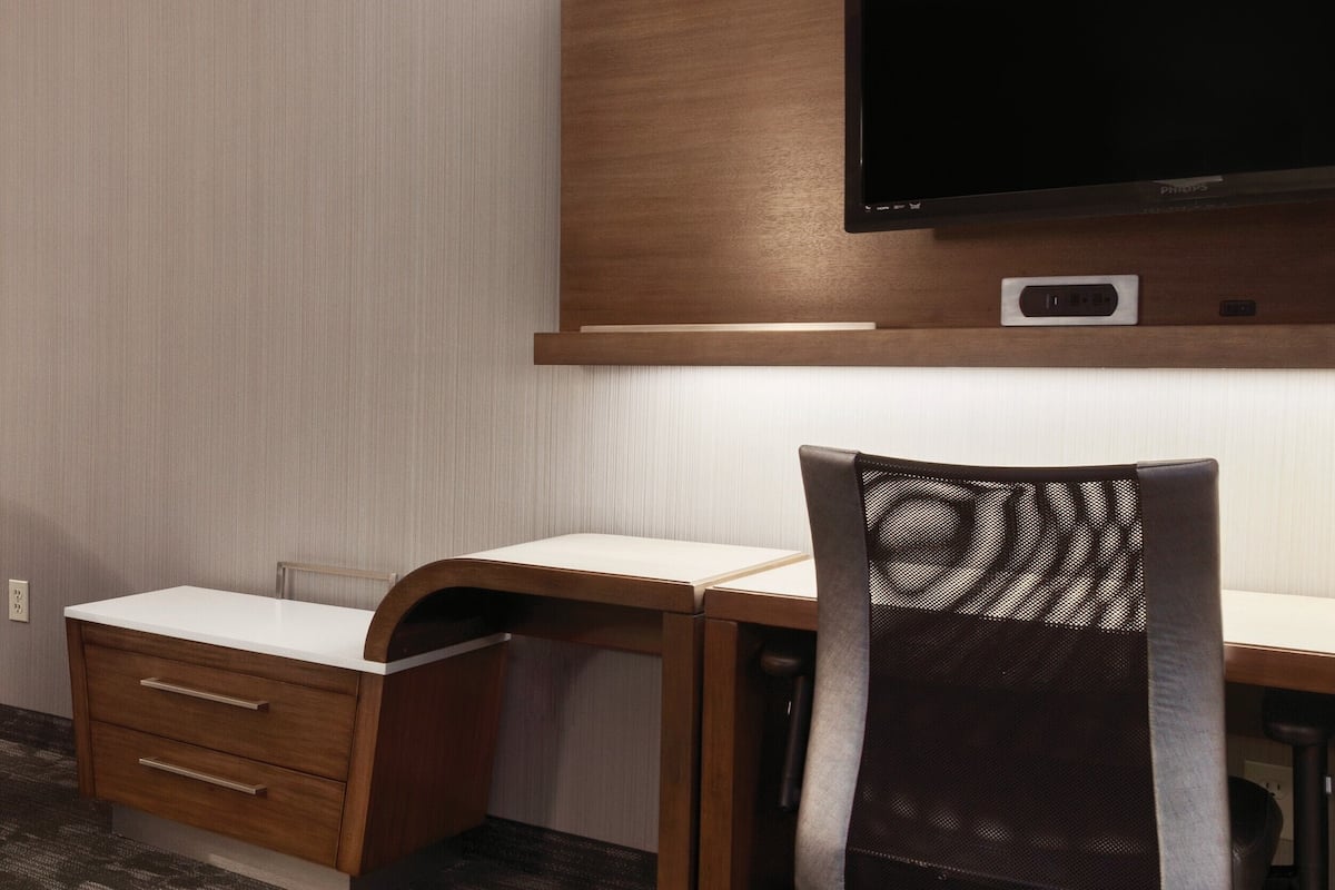 Roupas de cama premium, escrivaninha, espaço de trabalho para notebook