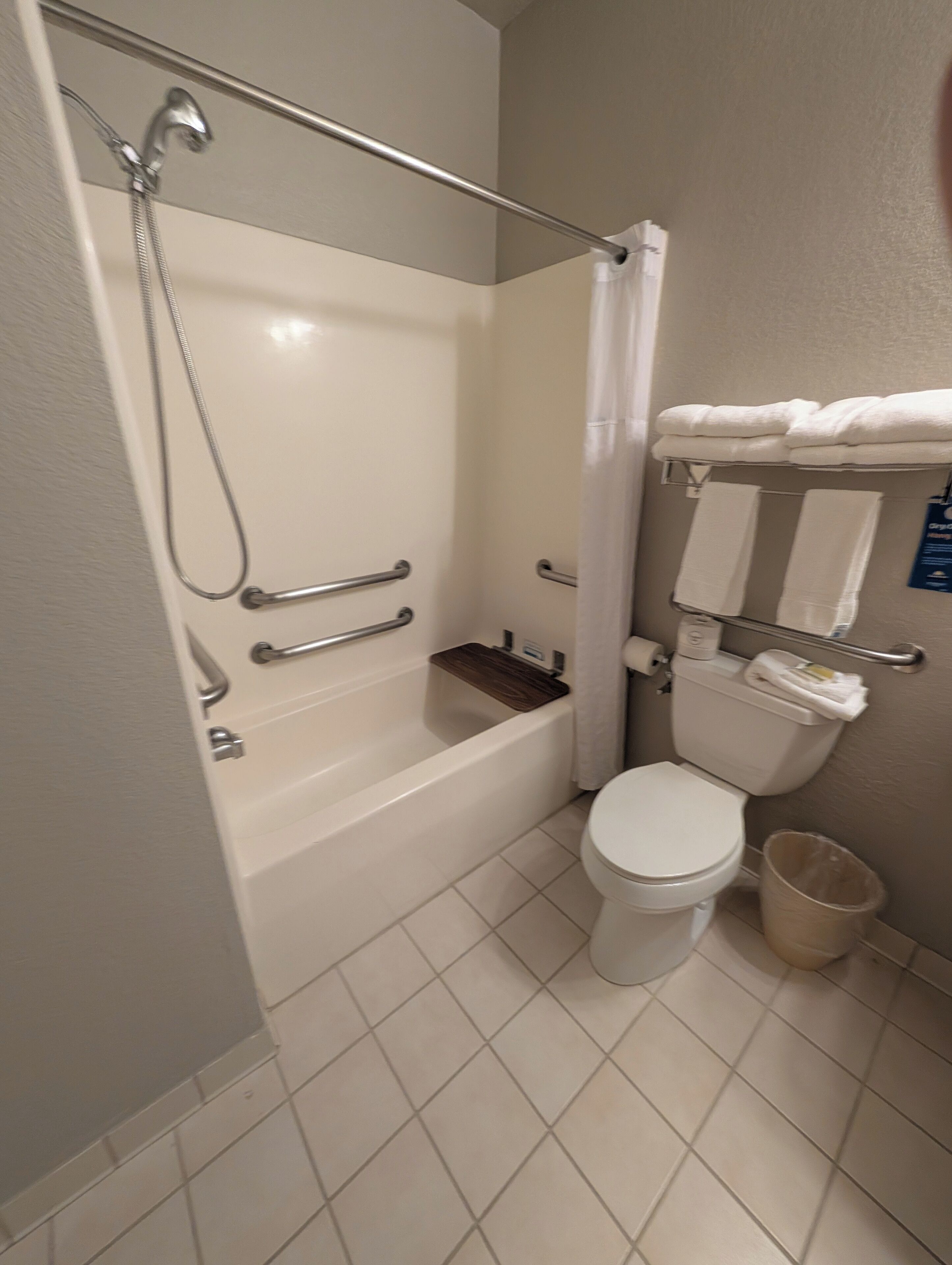 A bathroom with a bathtub, toilet, and a shower area.