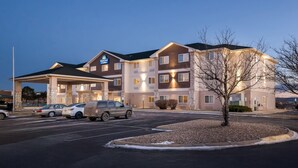 Un hôtel à plusieurs étages, doté d’une entrée abritée et de plusieurs places de stationnement.