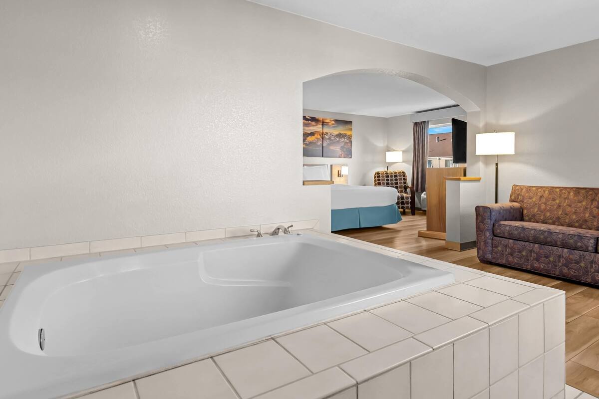 Un baño moderno con una bañera grande, un sofá y una zona de escritorio.