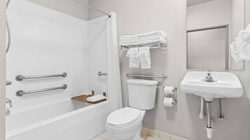 A modern bathroom with a bathtub, toilet, and sink.