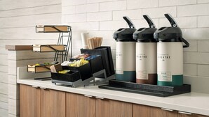 A counter with a coffee machine, a water dispenser, and a small trash bin. - Fairfield Inn Tallahassee North/I-10 (Tallahassee)