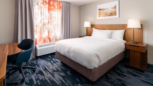 A hotel room with a bed, two bedside lamps, a desk with a chair, a window with curtains, and a wall-mounted picture. - Fairfield Inn Tallahassee North/I-10 (Tallahassee)